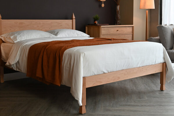 Cherry Samarkand bed base with white cotton bedding and a terracotta bedspread. The beds sits in a room set with other items of solid hardwood furniture and accessories.