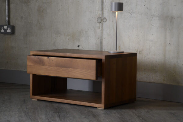 Image showing the Black Lotus one drawer bedside in walnut with a rechargeable lamp sat atop it.