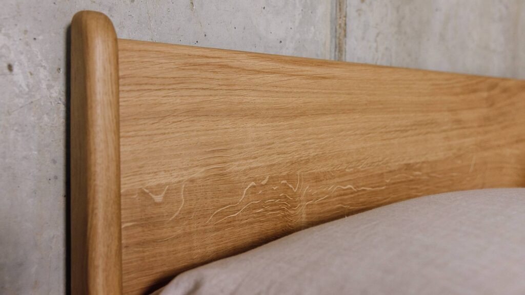 Close up shot of the silver figure on the English oak Camden's headboard panel.