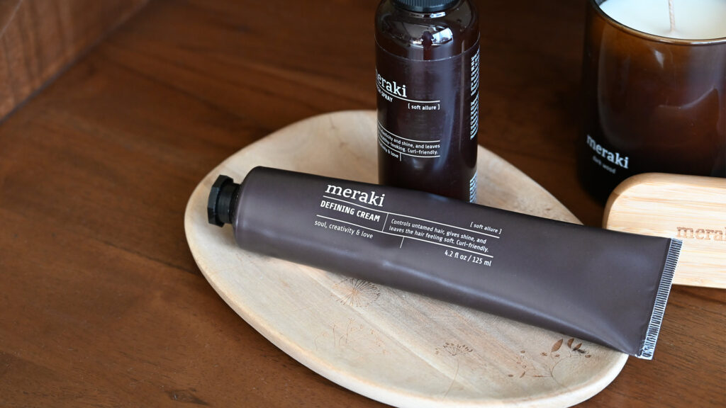 Defining cream for curly hair from Meraki. Closeup.