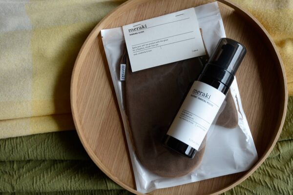 Meraki Tanning Mousse Glove on oak tray flat lay