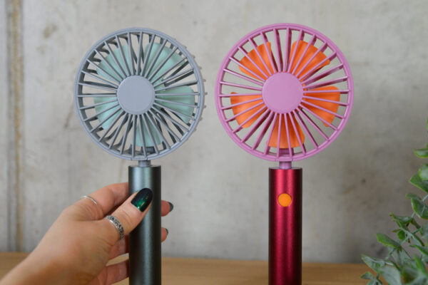 Handheld metalic fans, one berry pink, one graphite.