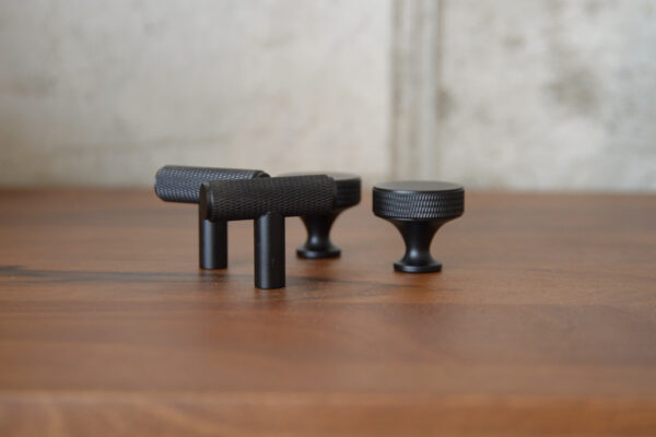 2 round black hooks and 2 t bar black hooks on table.