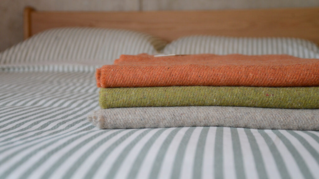 stack of three throws - orange, green and greige.