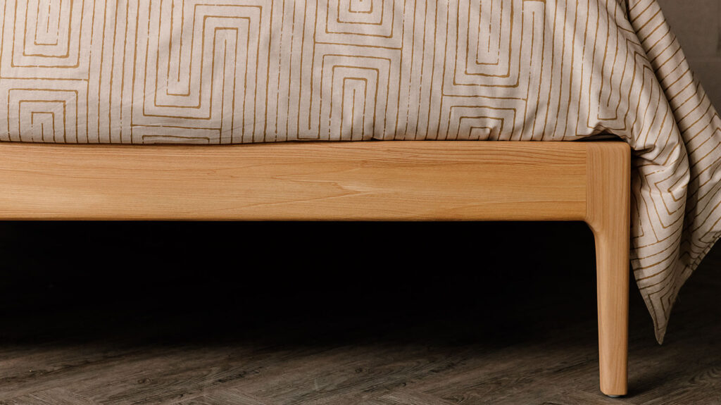 Scottish Elm Camden bed - leg detail to show handmade curved element. Cropped view.