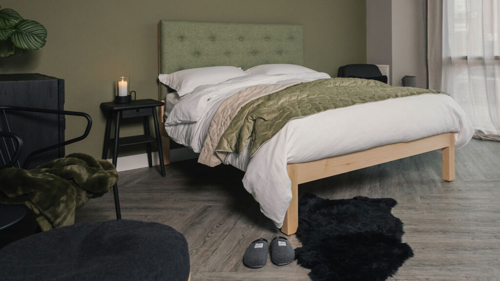 Skye upholstered bed with green headboard velvet throw and white muslin bedding