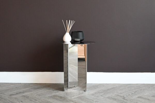 Fully stainless steel side table with diffuser and candle holder on top.
