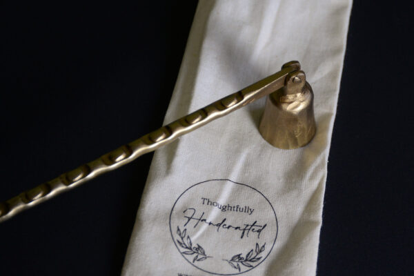 aged brass look textured candle snuffer close up with bag
