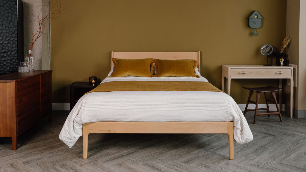 Beech Camden bed with textured stripe bedding and gold ochre velvet cushions.