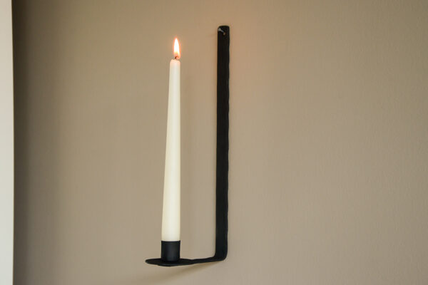 black wall mounted candlestick holder side view lit