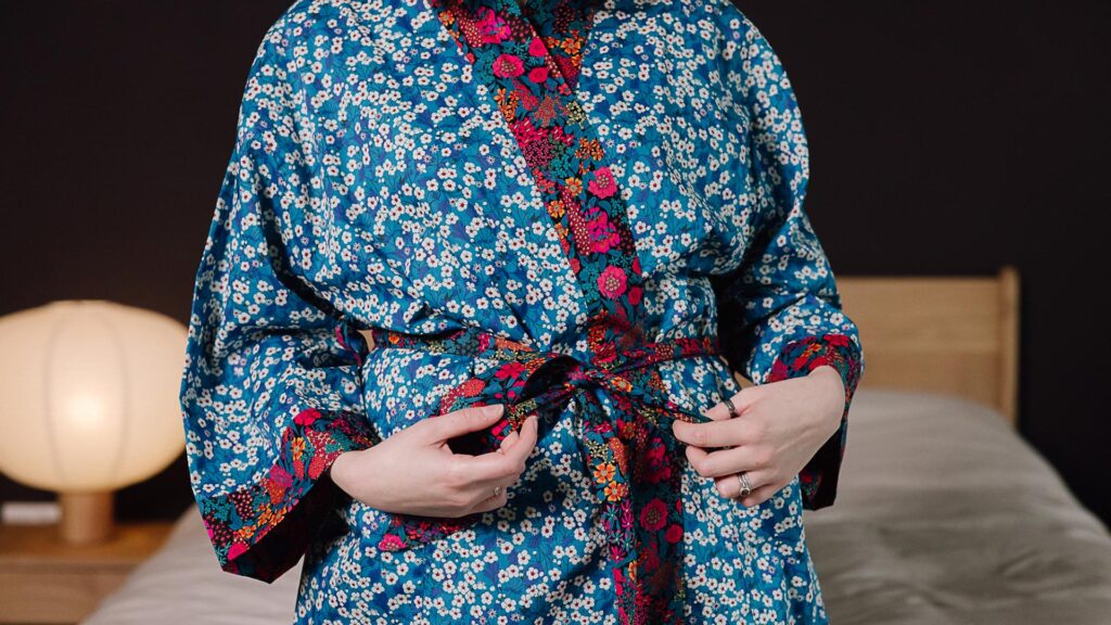 Close up of red tie on blue liberty print robe.