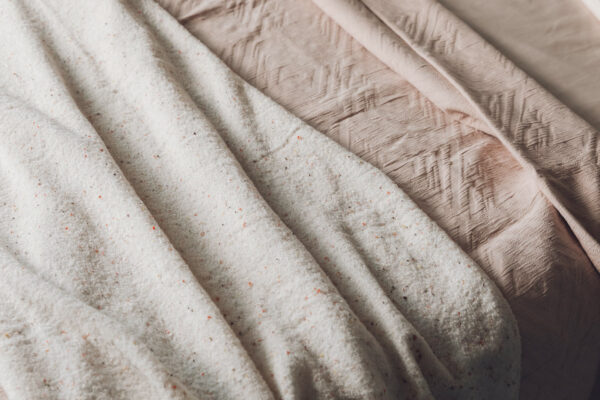 blush pink bedding with speckle throw detail