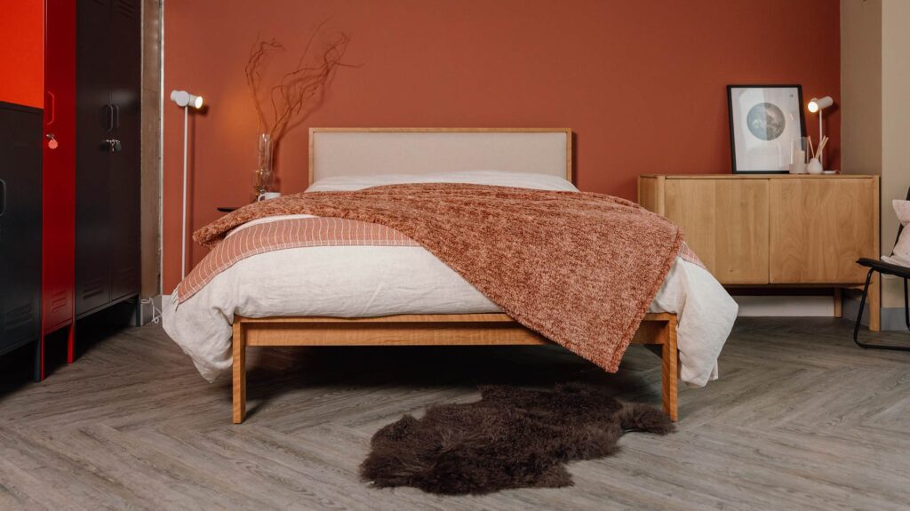 cherry wood Shetland bed with Amatheon headboard panel and longhair sheepskin throw brown