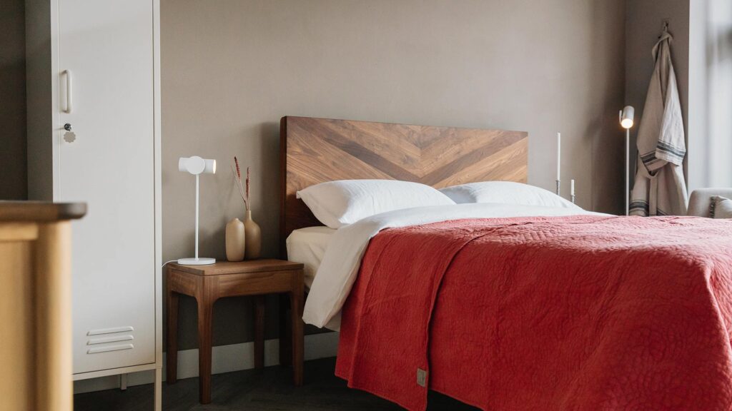 coral bedspread on walnut bed