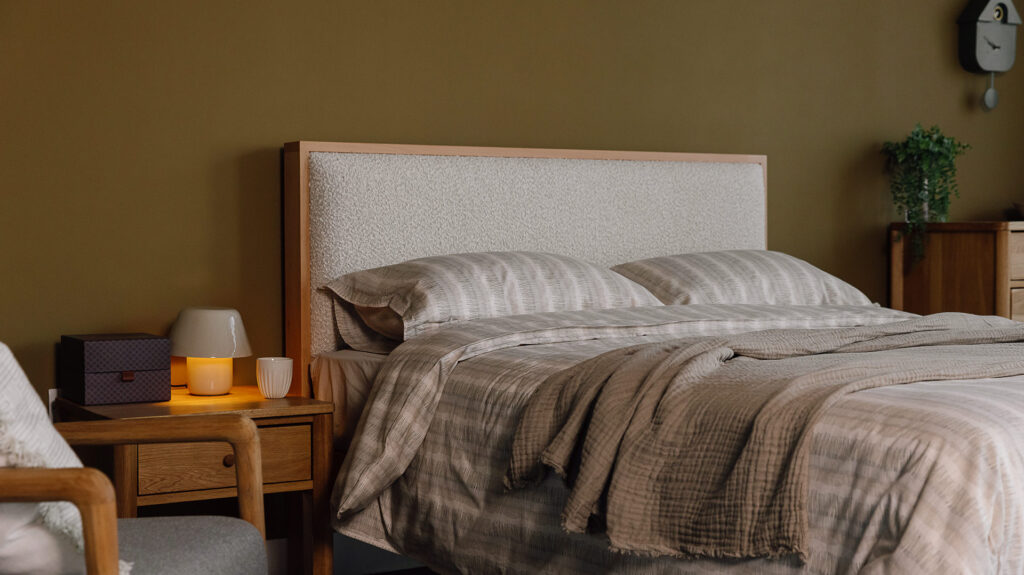 Beech Shetland bed with Andes Ecru upholstery and neutral stripe bedding in cosy room setting.