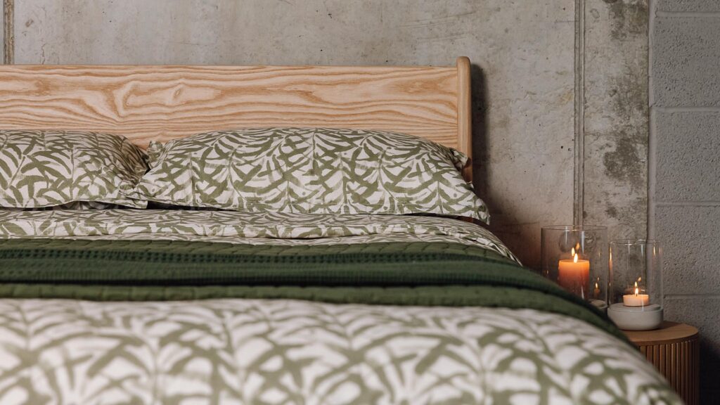 Wild Ink duvet set with watercolour green leaf print and dark green throws.