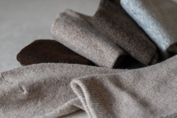 4 Pairs of folded socks in browns and grey.