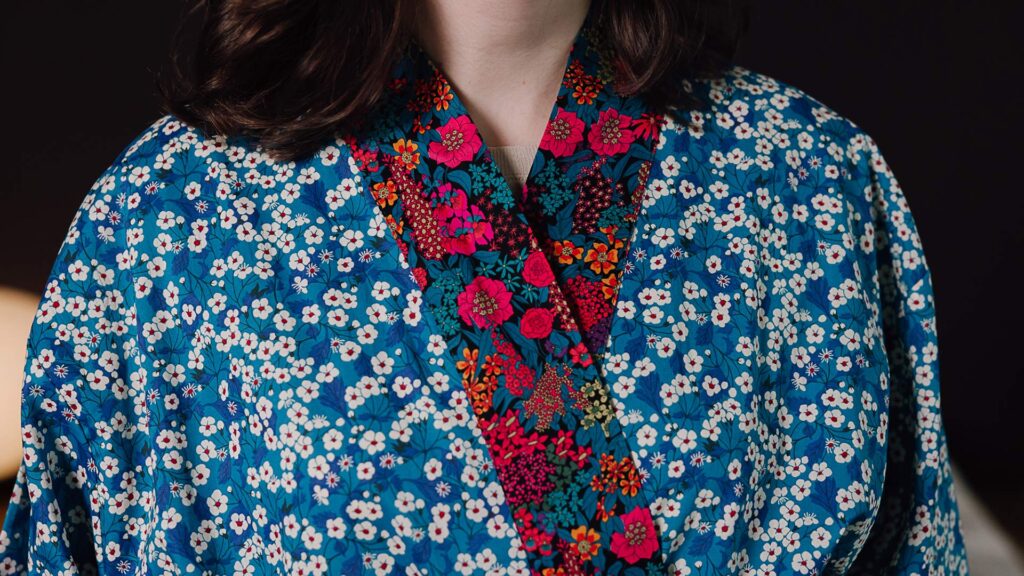 Close up of red hem on blue liberty print robe.