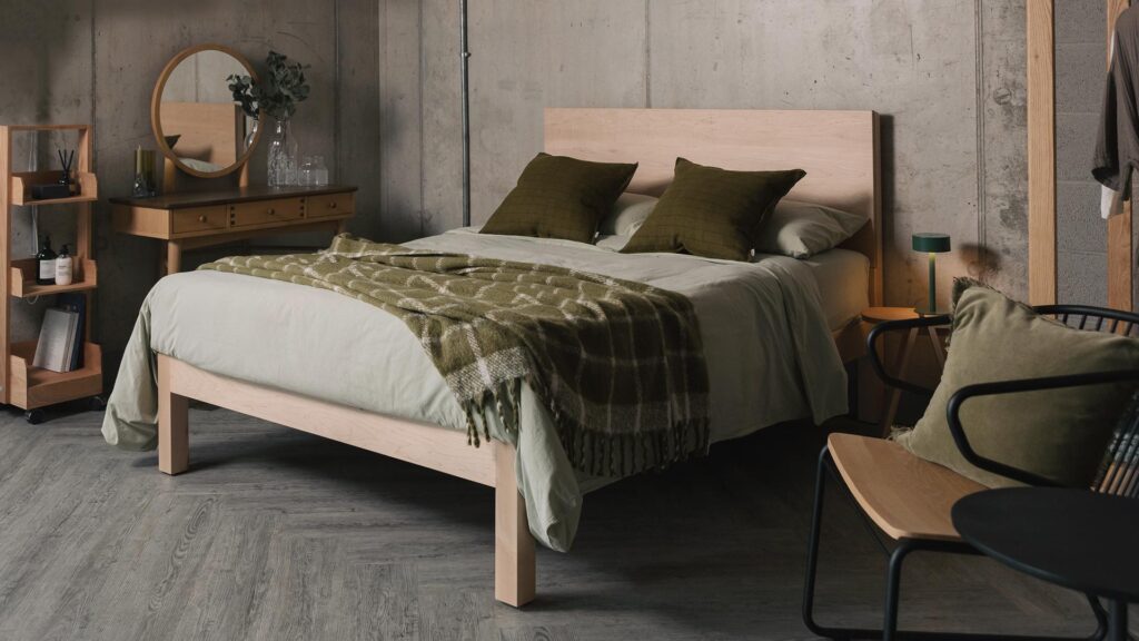 maple Bamford bed with olive green check throw