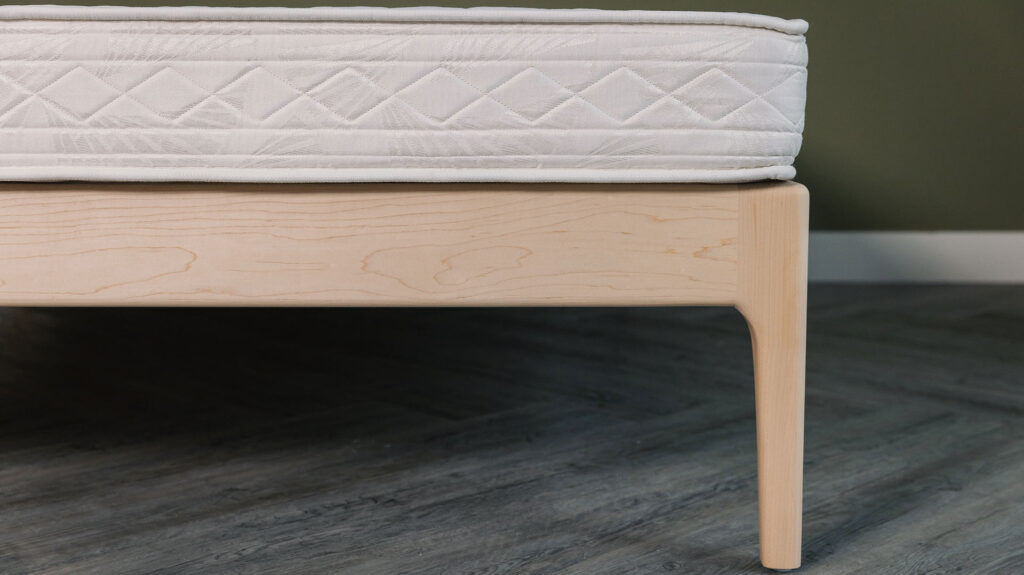 Camden bed curved leg detail in solid maple wood.