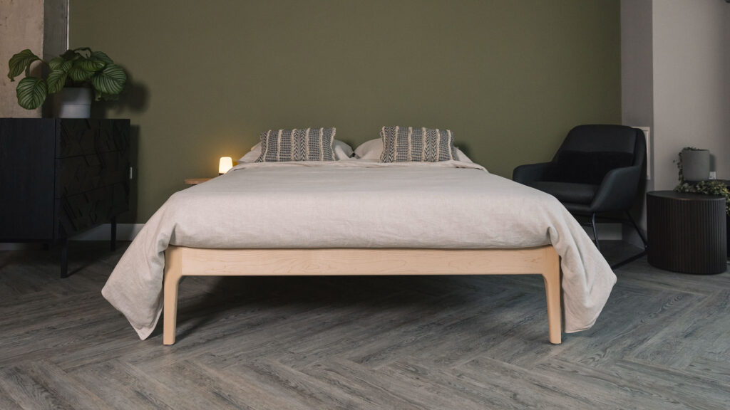 Front view of the Camden without a headboard in solid maple. Dressed with beige linen and boho style cushions.