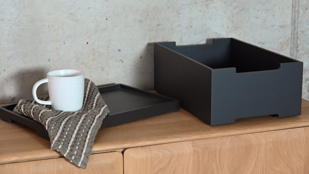Deep grey storage box next to the matching tray/lid.