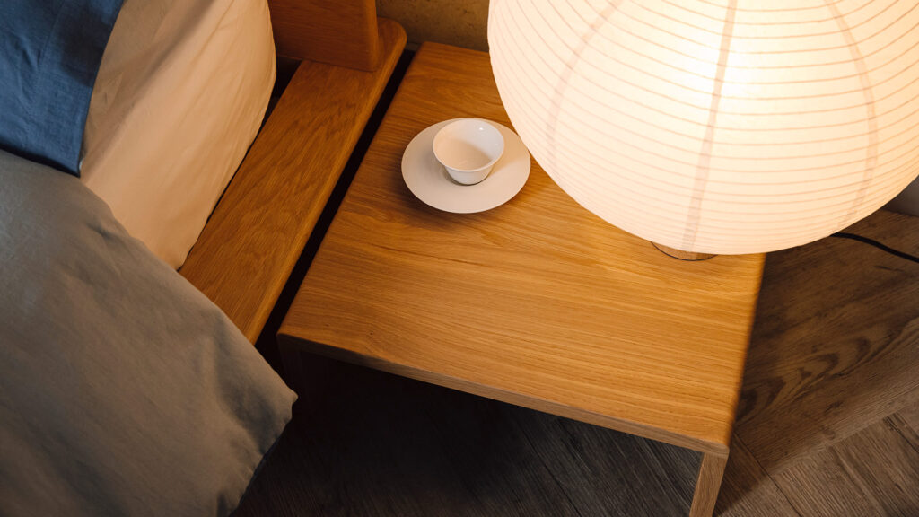 Table top of low Portland bedside table. Japanese style paper lamp on top.