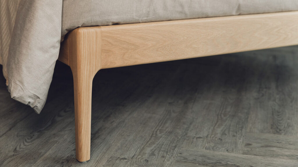 oak camden bed curved leg close up.