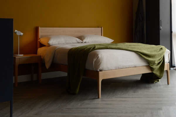 solid oak camden bed base with beige linen bedding and olive green textured bedspread.