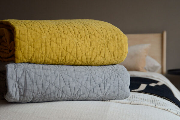 ochre and grey hexagon embroidered bedspreads stack