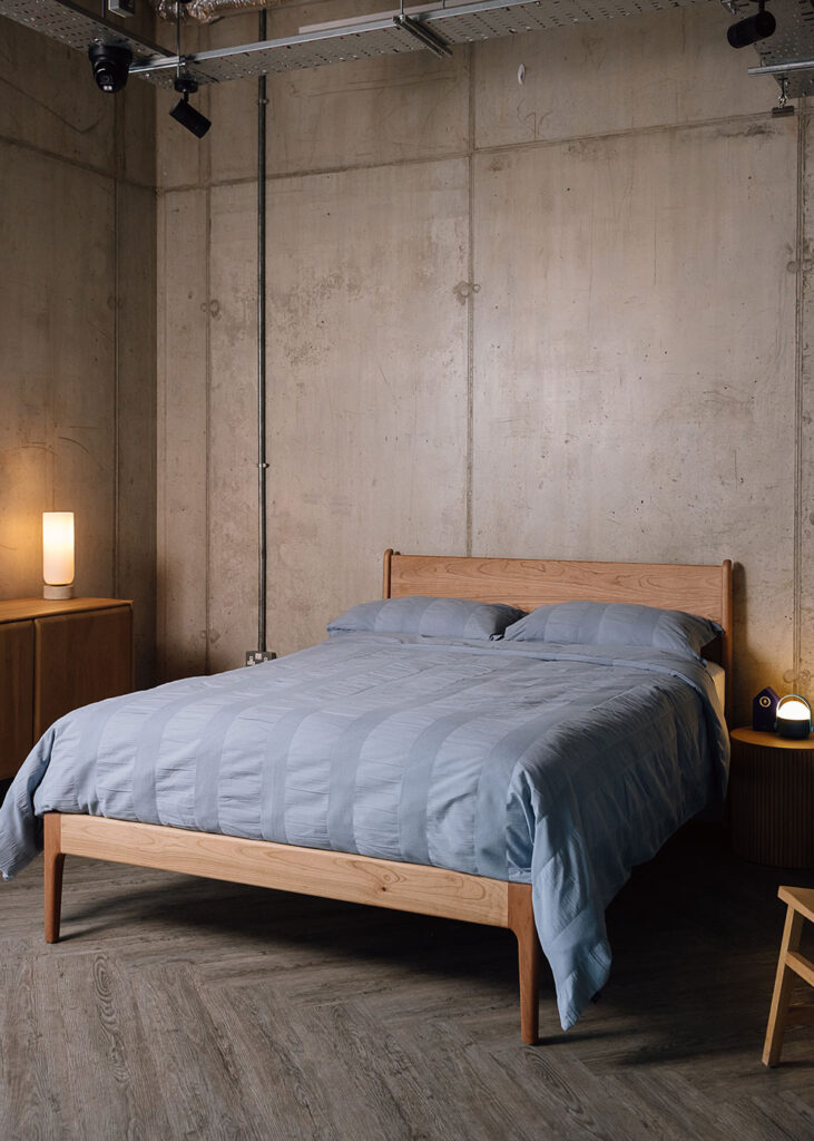 Solid cherry Camden bed frame with blue cotton bedding.