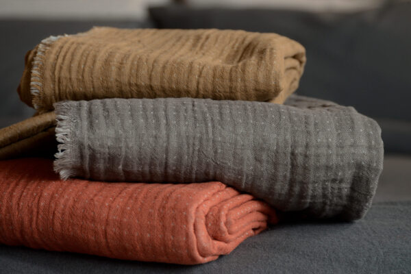 reversible cotton throws stack tan grey and rust