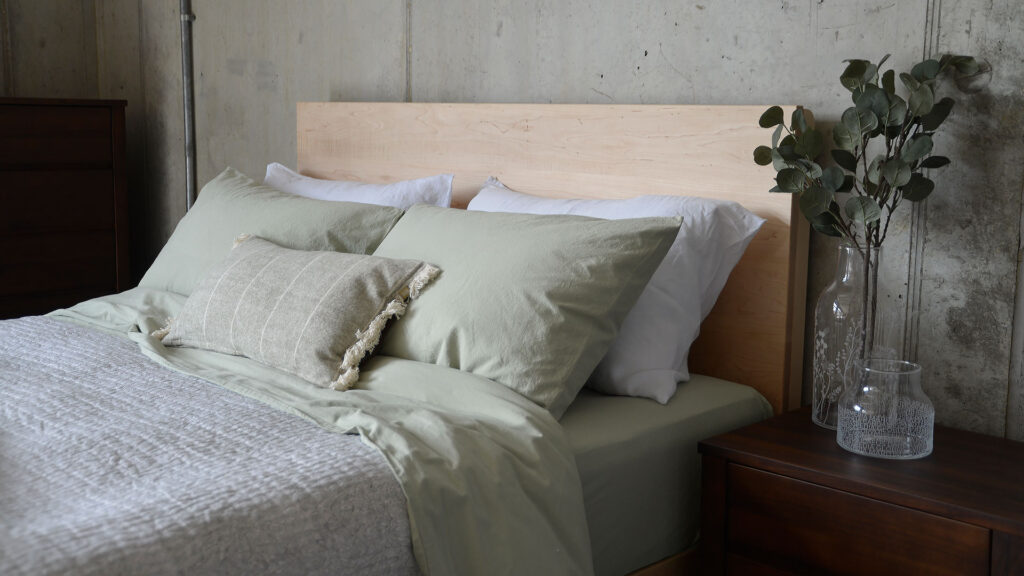 soft green stonewash cotton bedding with maple Bamford bed