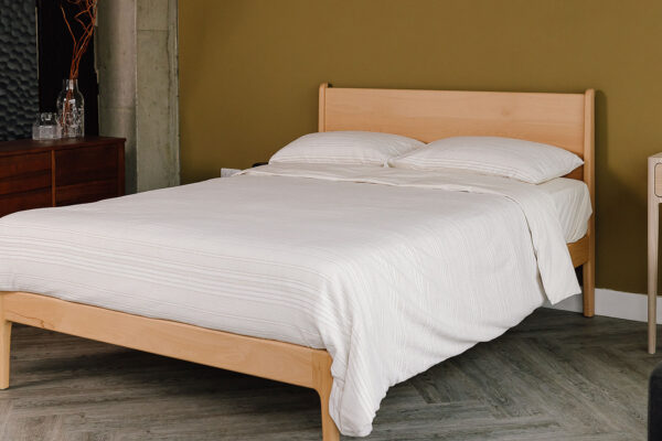 Beech Camden bed with softly textured cotton duvet set. Angled view.