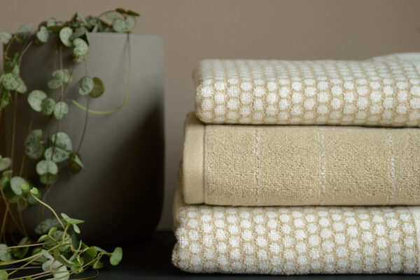 stack of beige and white towens with plant