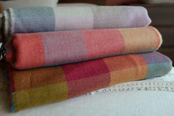 stack of multicolour check lambswool throws   3 colourways
