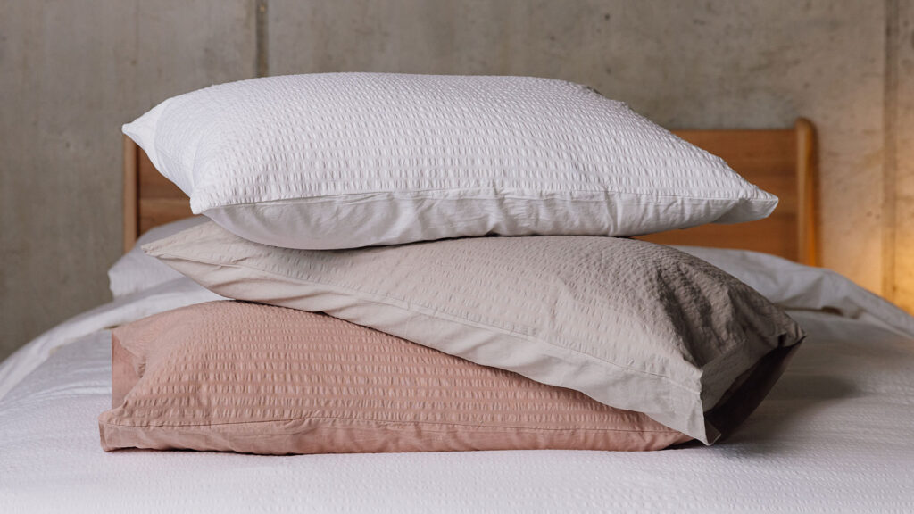 Stack of pillows with seersucker pillowcases in varying colours to show range.