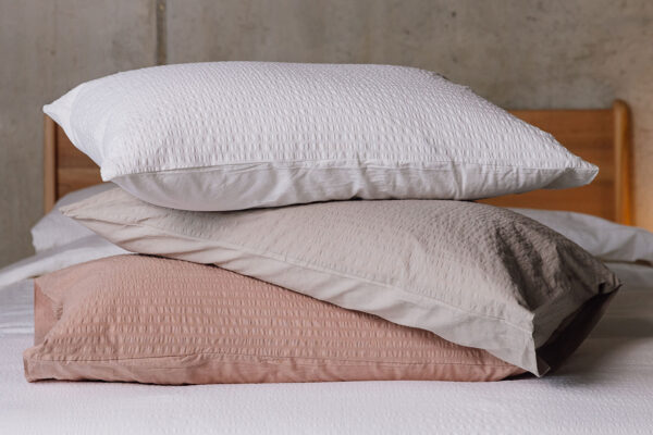 Stack of pillows with seersucker pillowcases in varying colours to show range.