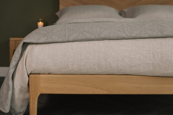 stone and taupe bedding on oak bed