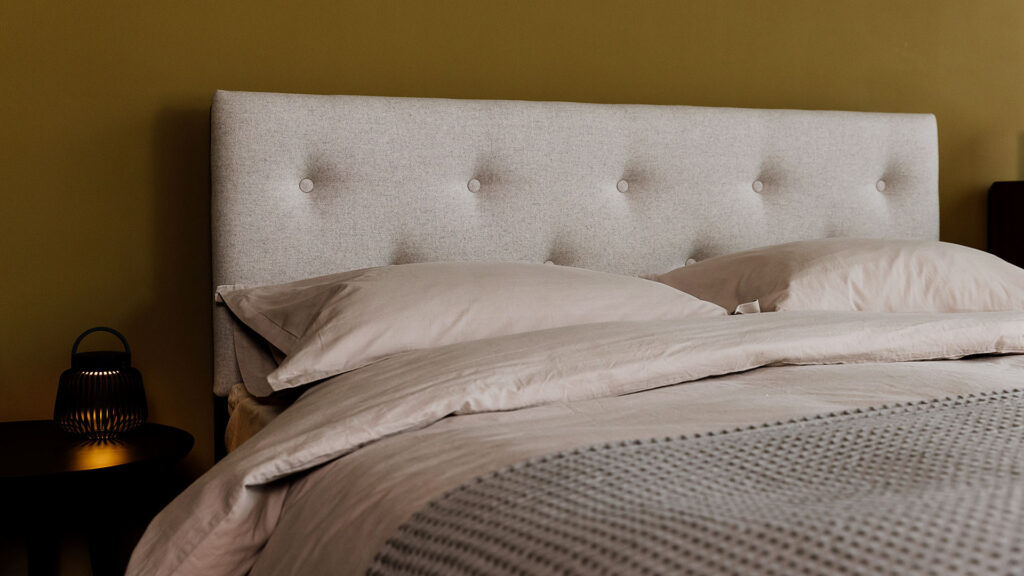 Stonewash bedding on a modern upholstered bed frame.