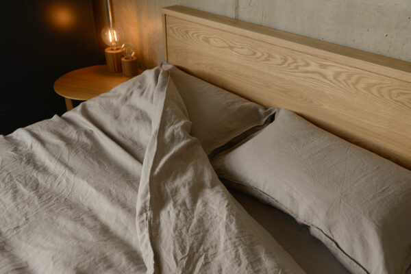 taupe linen bedding and oak Leith headboard detail